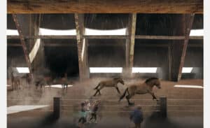 Chevaux galopant dans un enclos couvert, soulevant de la poussière. Des personnes les regardent depuis l'extérieur d'une clôture. L’arrière-plan montre une grande structure avec des ouvertures lumineuses.